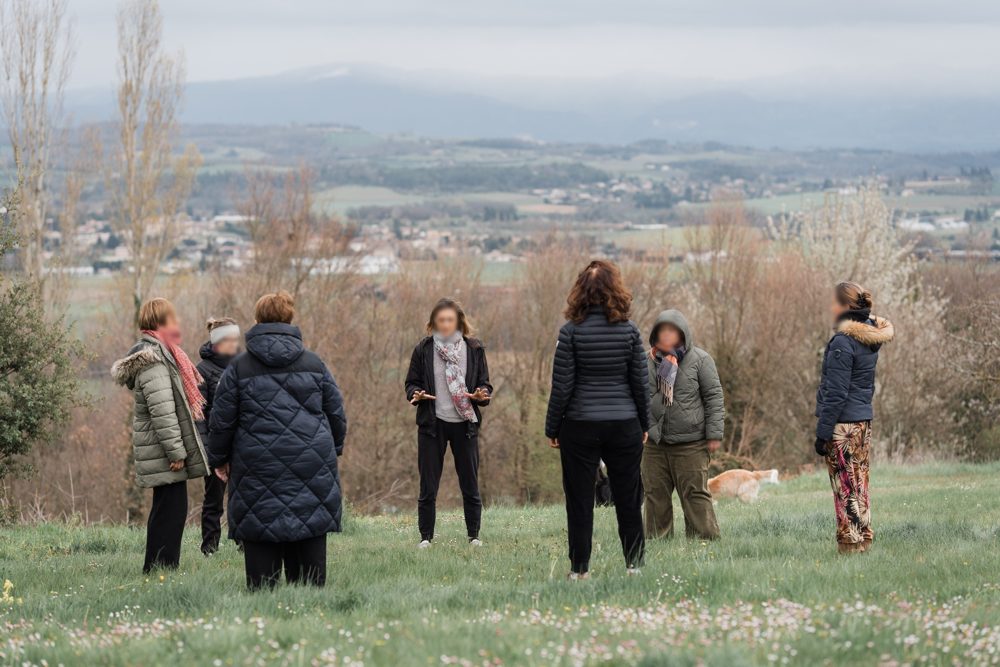 Un groupe en cercle dans la prairie, face à la vallée